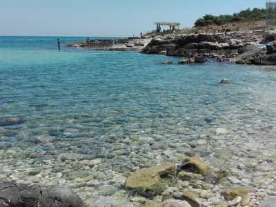 La prima caletta che ci troviamo davanti si presenta come una piccola insenatura dominata da tanti piccoli ciottoli bianchi che lasciano spazio alla sabbia non appena si entra in acqua, che qui appare di un colore azzurro cristallino